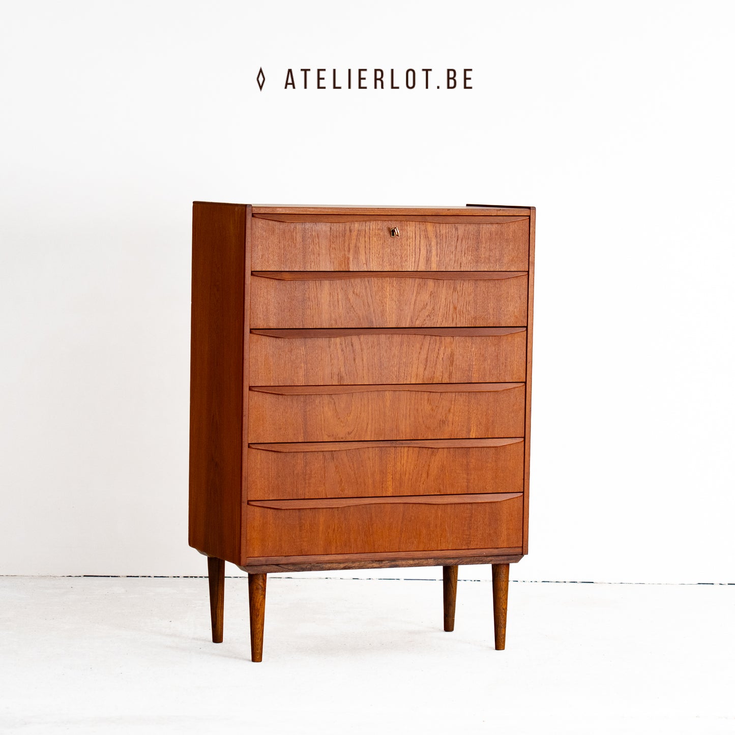Vintage ladekast teak met 6 schuiven Deens design, schuin vooraanzicht met sleutel in slot