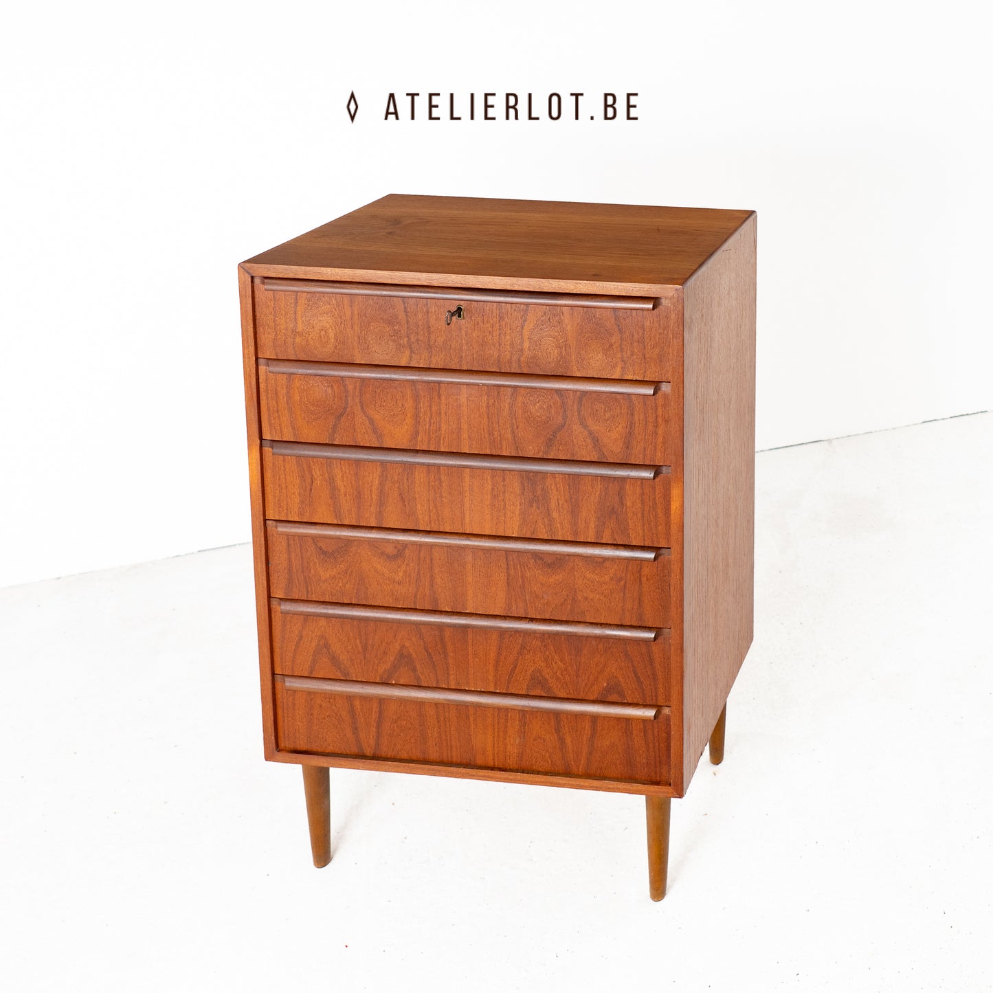 Vintage ladekast teak met lijstgrepen Deens design, schuin bovenaanzicht met sleutel in slot